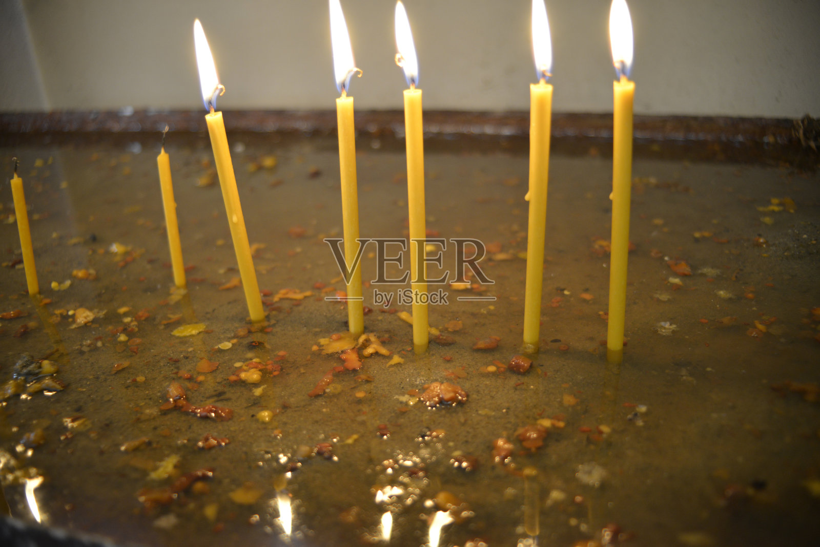 在教堂里燃烧蜡烛,在安全灯座里用水照片摄影图片