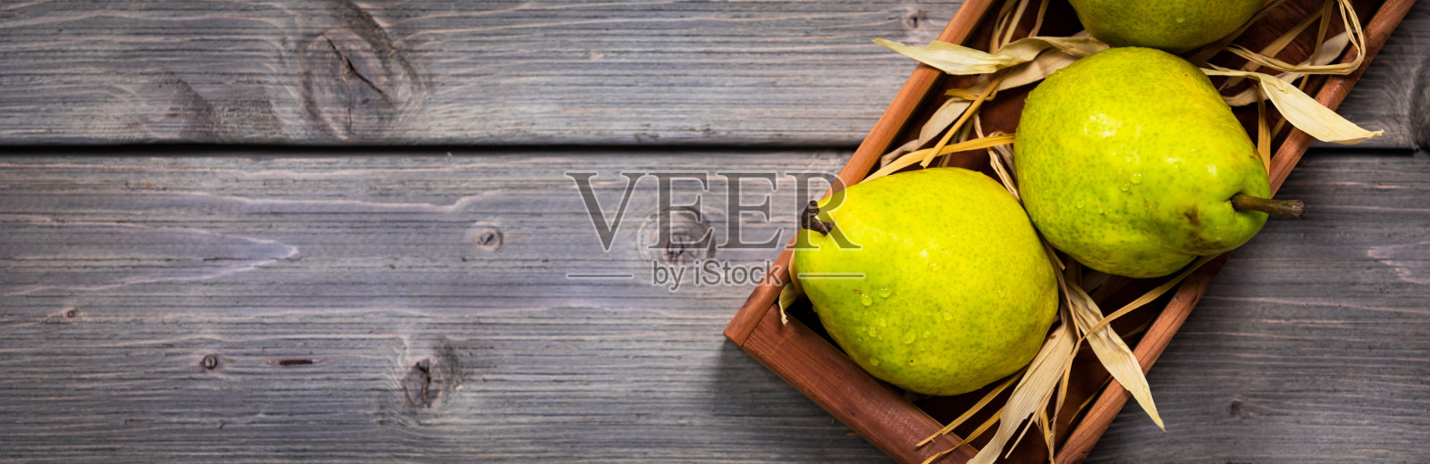 木桌上的新鲜熟透的绿梨照片摄影图片