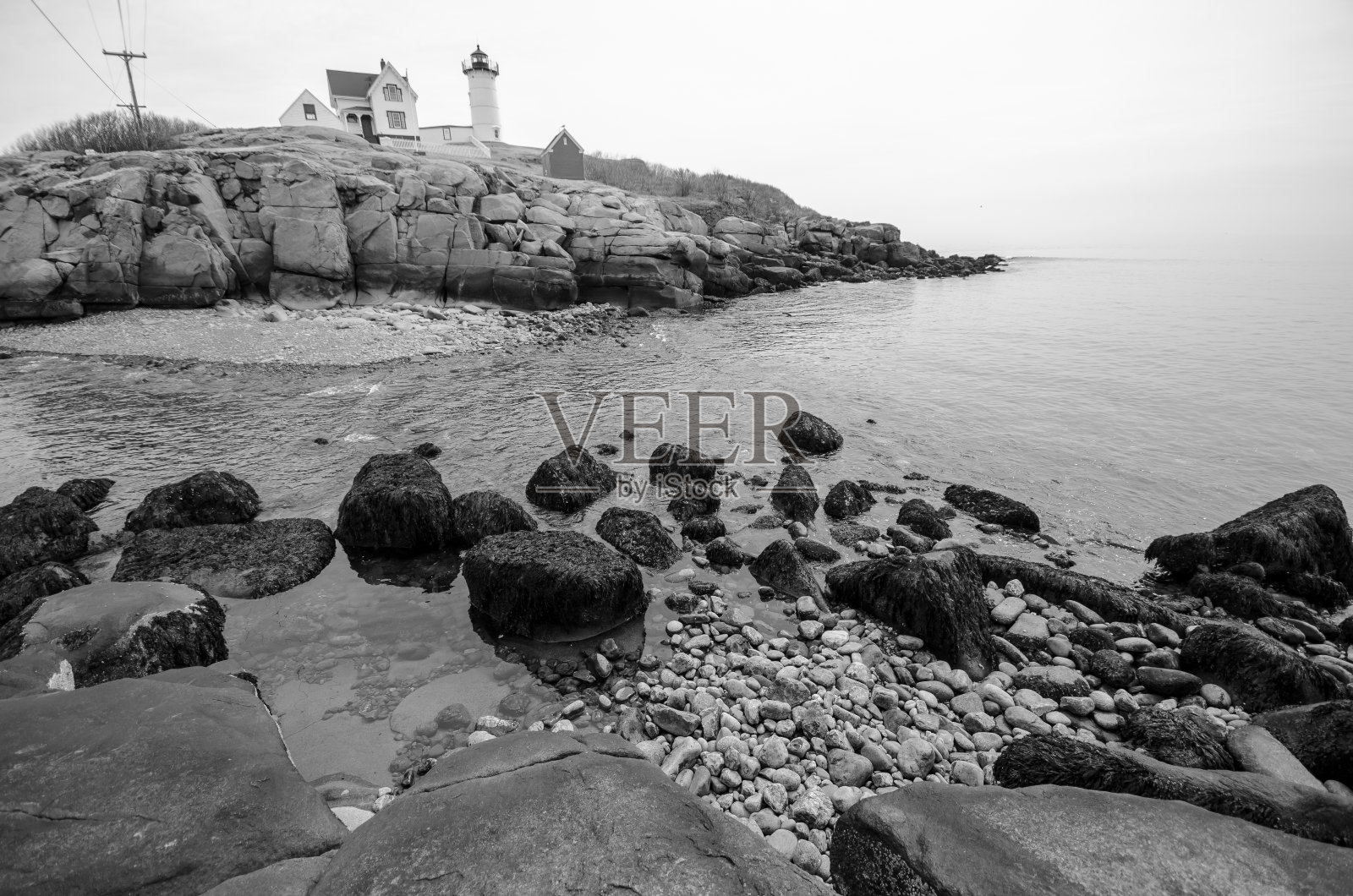 缅因约克内迪克角的努布尔灯塔。海浪和海洋在前景,黑白视图照片摄影图片