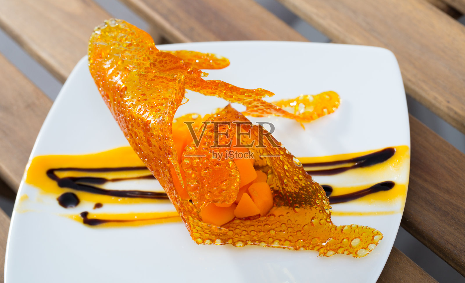 近距离接近美味的甜点甜胡萝卜方块与焦糖和香草酱照片摄影图片