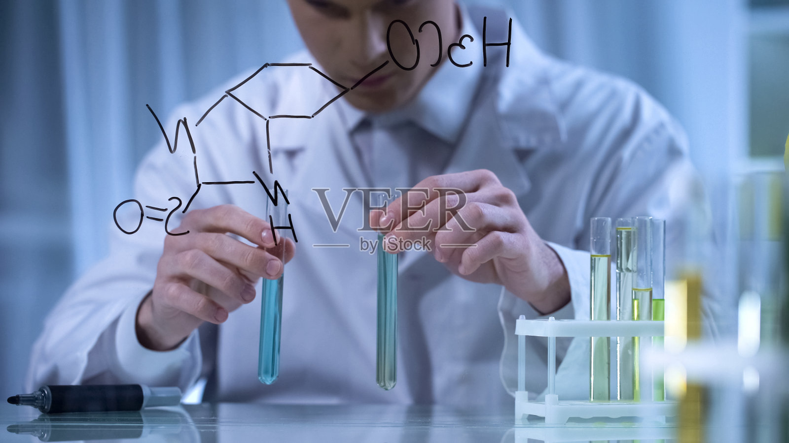 研究人员根据写在玻璃上的公式在试管中混合试剂照片摄影图片