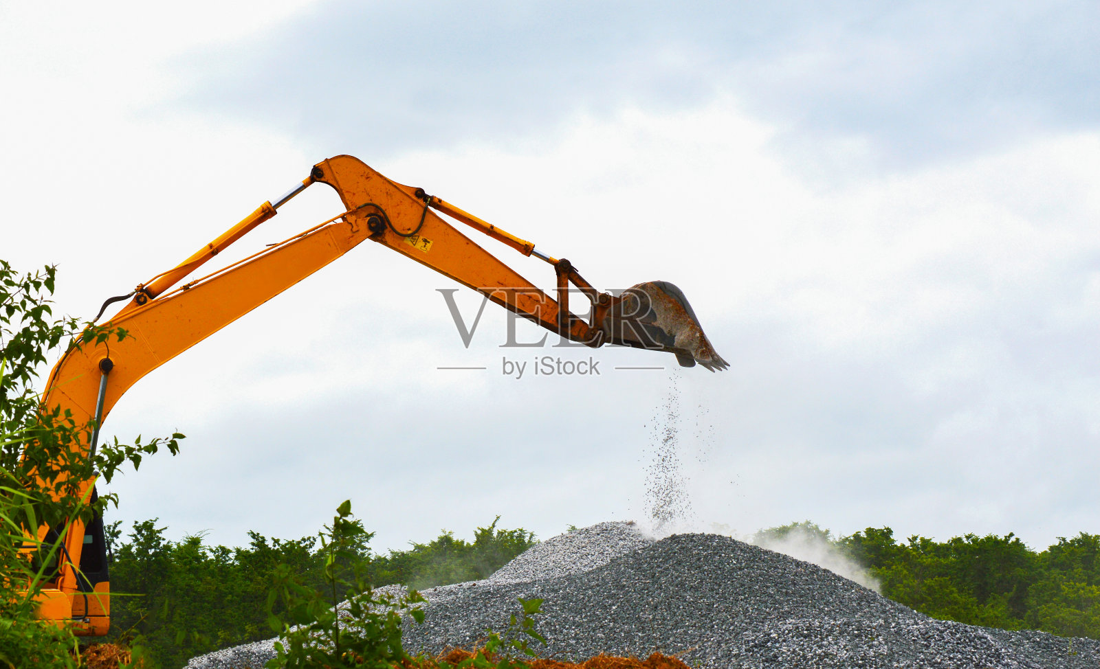 在堆石堆上工作的反铲装载机/工业概念的大型重型挖掘机照片摄影图片