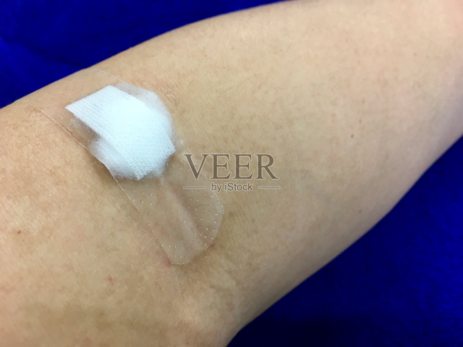 验血后在手臂上贴纱布。照片摄影图片