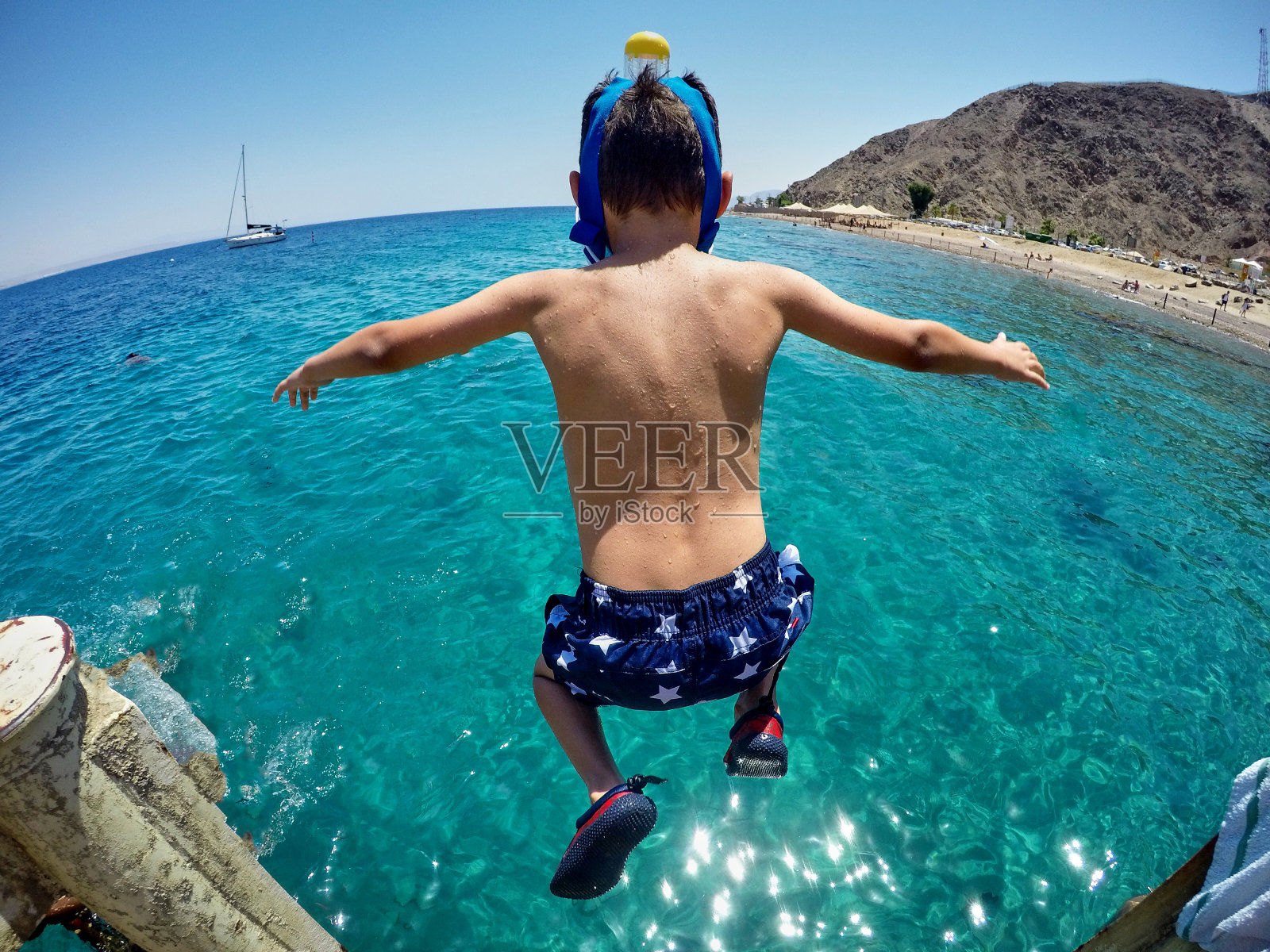 那个男孩正在往海里跳照片摄影图片