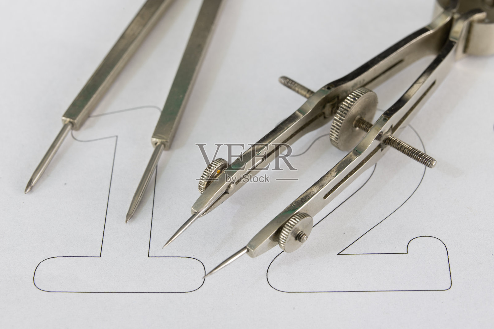 一个在白纸上画圆圈的同伴。用于绘制技术图纸的绘图附件。光背景。照片摄影图片