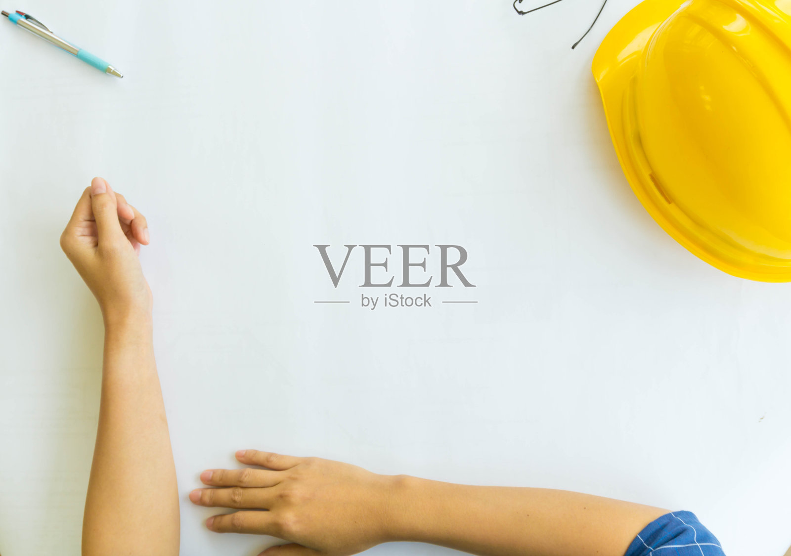 近距离的手工程师工作的建设计划。她坐在办公室里一张设计图旁边的桌子旁。照片摄影图片