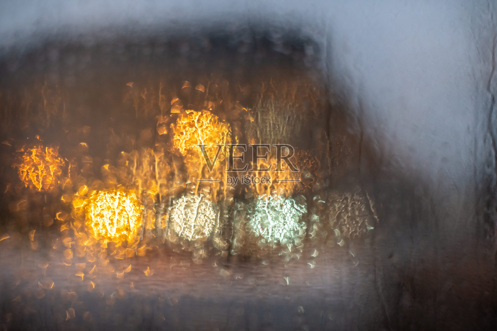 黄色的散景模糊的街灯。雾蒙蒙的窗口。户外照明。照片摄影图片