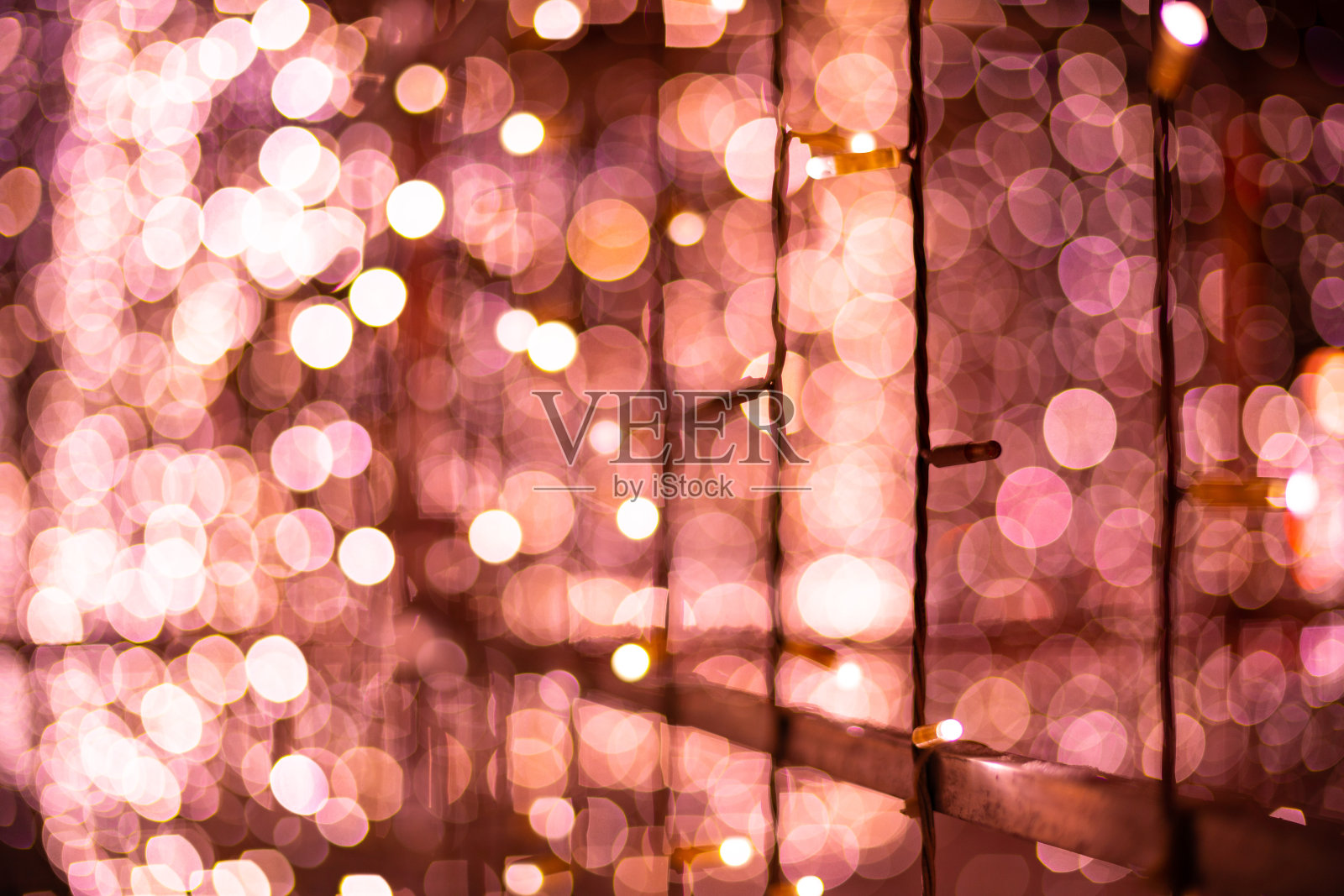 粉色散景模糊灯光背景。玫瑰花环装饰新年节日庆祝活动。照片摄影图片