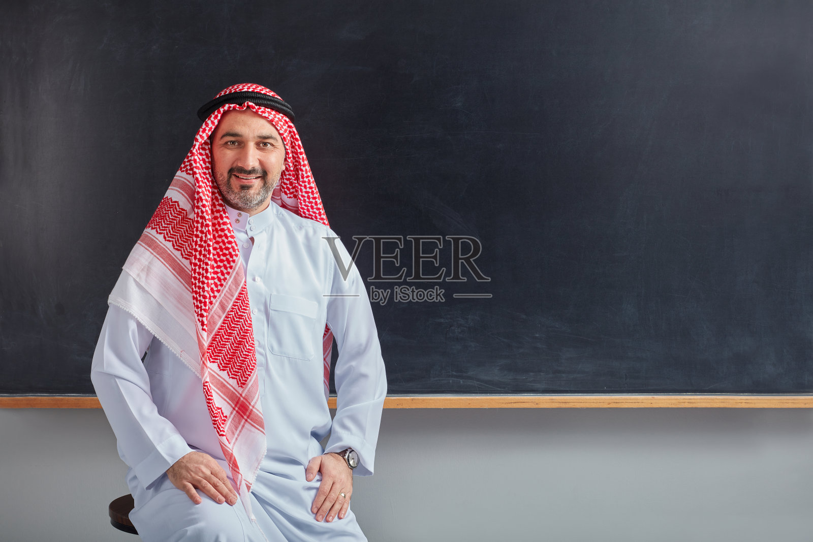 在黑板前摆姿势的阿拉伯教师照片摄影图片