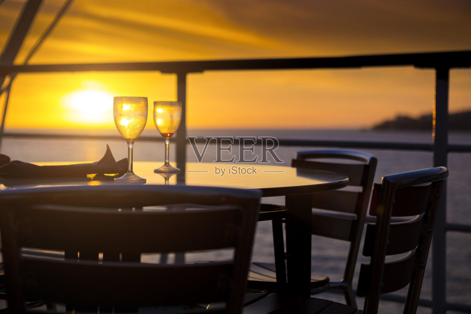 阳台上的酒杯可以俯瞰日落照片摄影图片