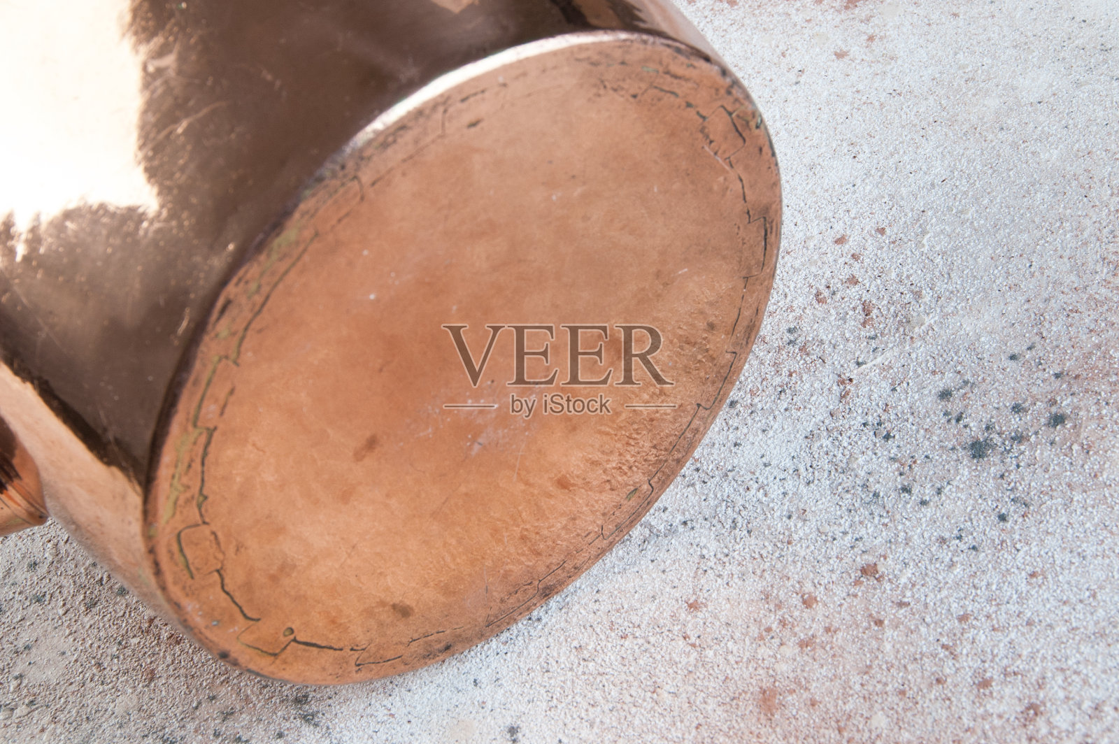 混凝土背景上的老式铜水壶。照片摄影图片