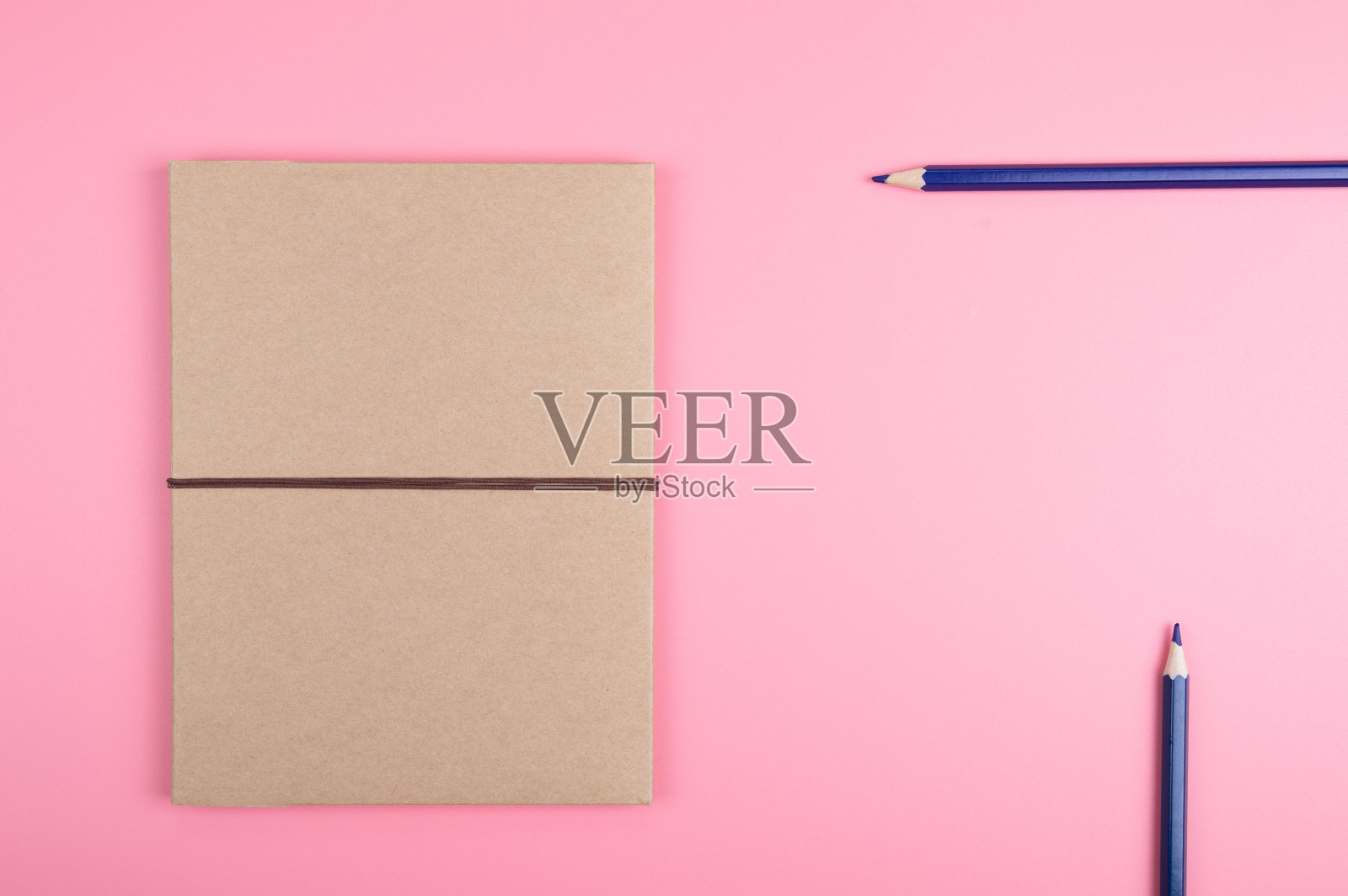 红色背景上的棕色笔记和彩色铅笔照片摄影图片