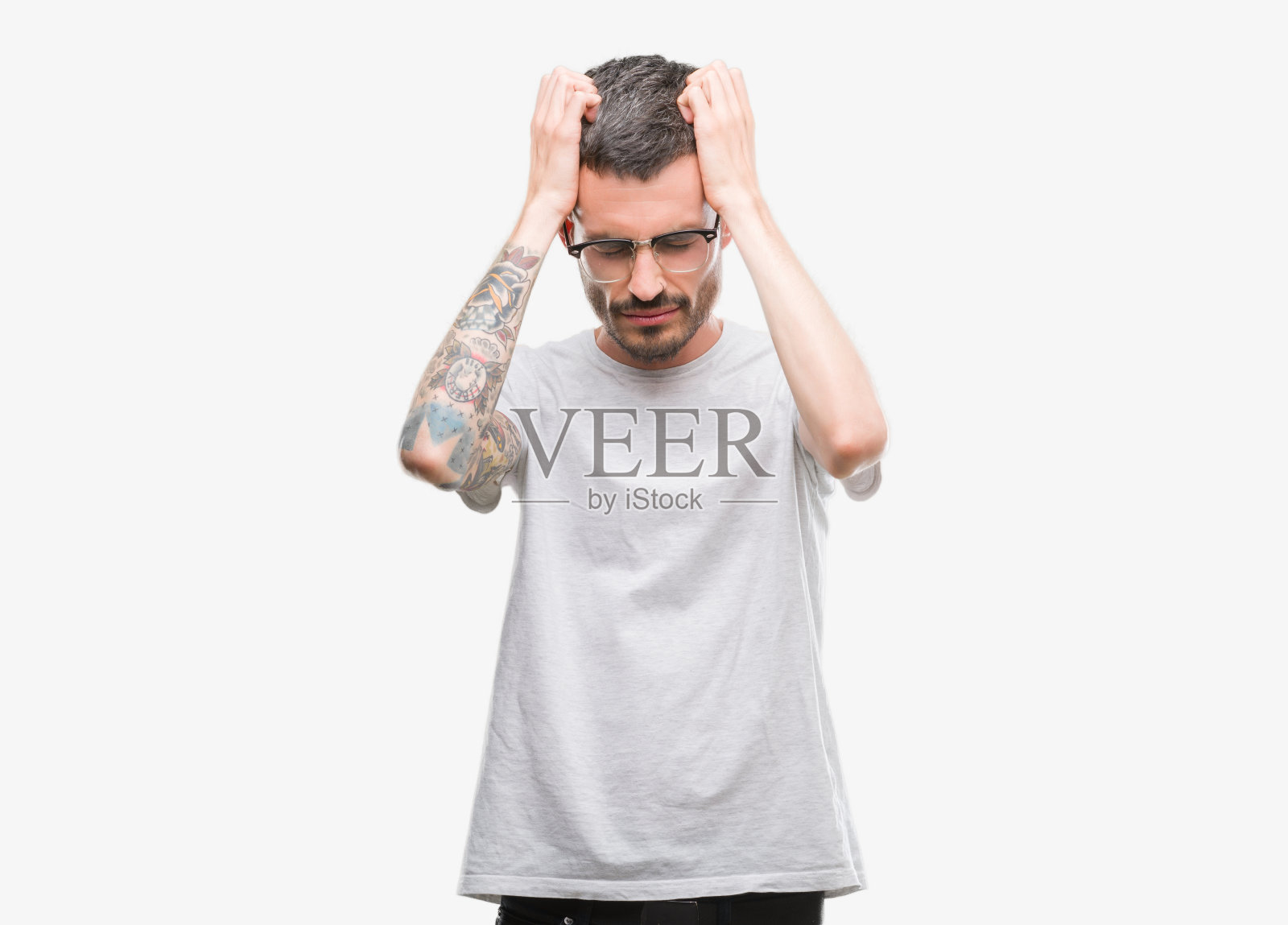 年轻的纹身成年男子遭受头痛绝望和压力,因为疼痛和偏头痛。手放在头上。照片摄影图片