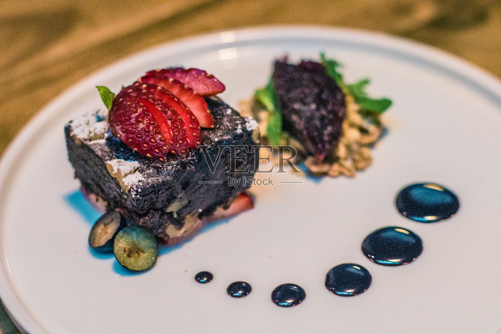 草莓巧克力布朗尼配巧克力酱和果酱照片摄影图片