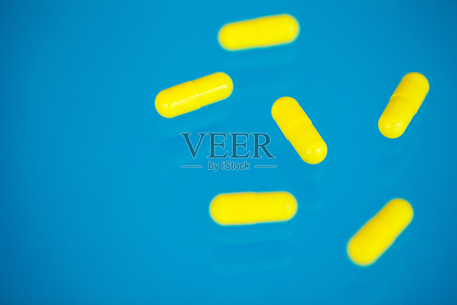 医学药。蓝色背景上的彩色药丸和胶囊。药房主题,胶囊药丸与药物抗生素包装照片摄影图片