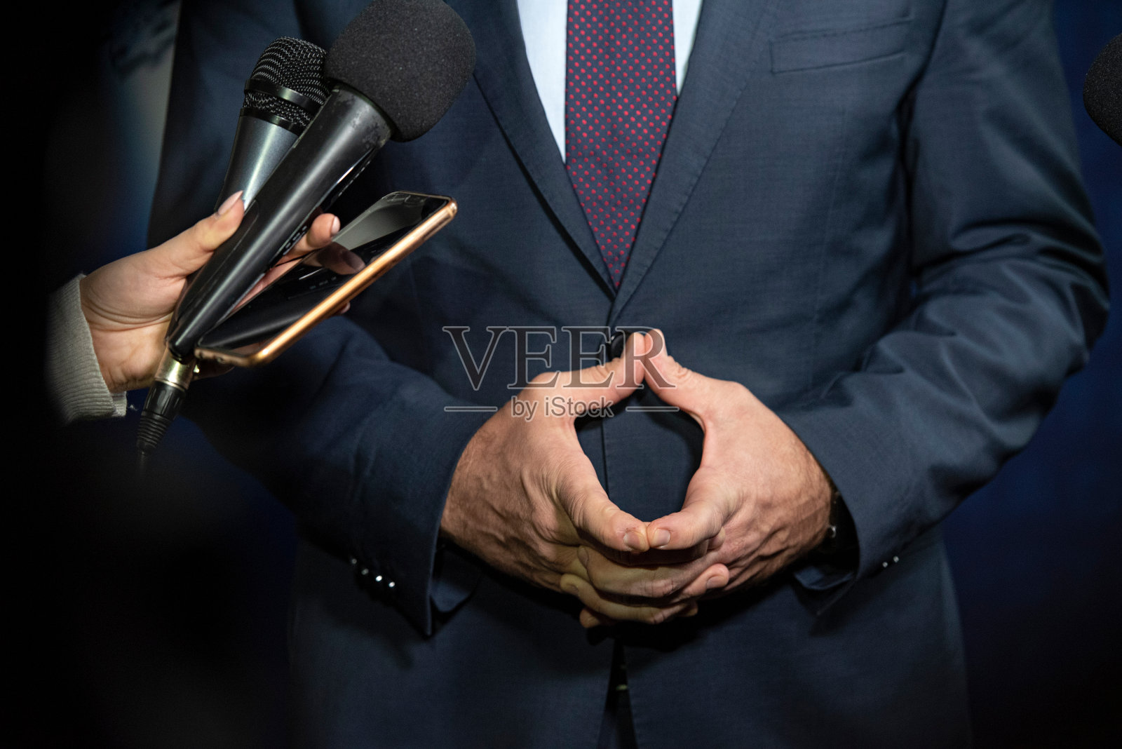 记者在记者招待会上紧握着双手向政治家提问照片摄影图片