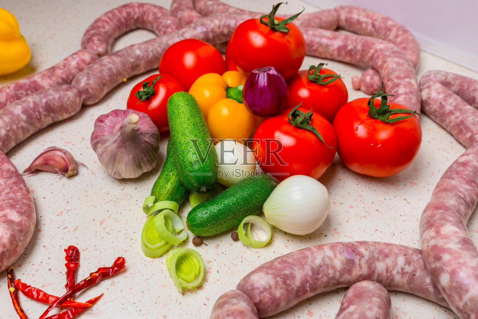 烧烤用的什锦生香肠配蔬菜。照片摄影图片