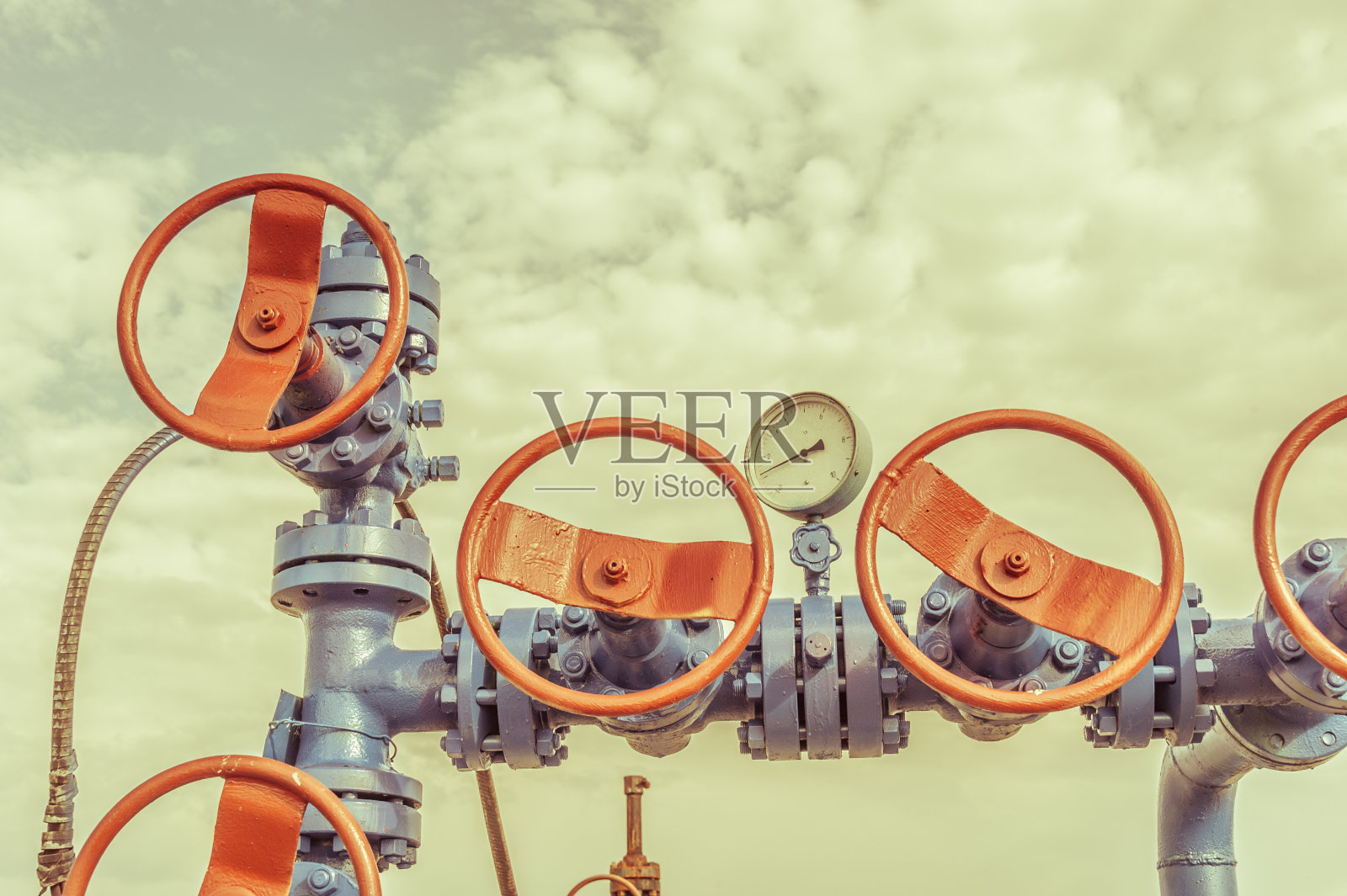 油田上带有阀电枢的井口。照片摄影图片