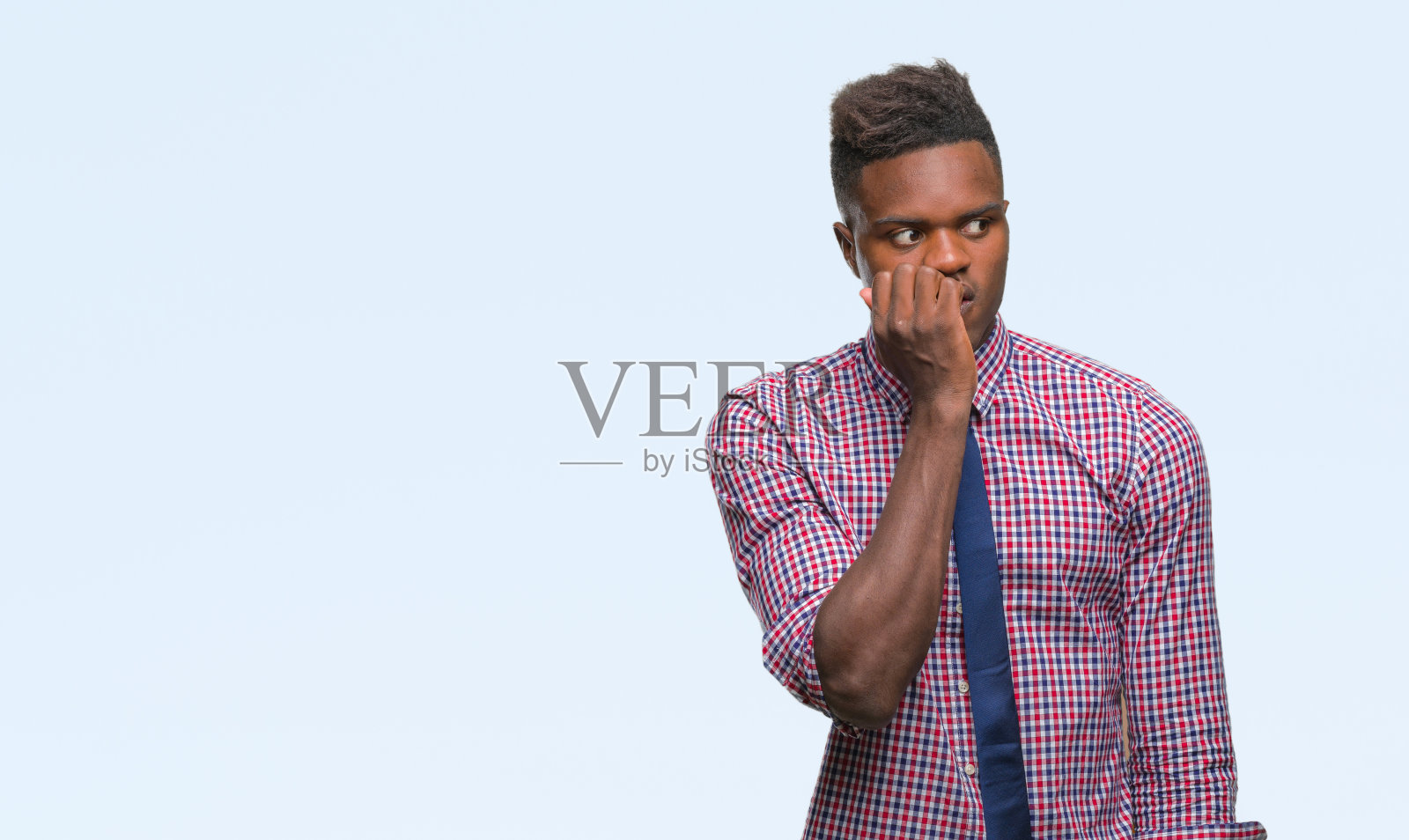 年轻的非洲裔美国商人,背景孤立,看起来紧张和紧张的手在嘴咬指甲。焦虑的问题。照片摄影图片