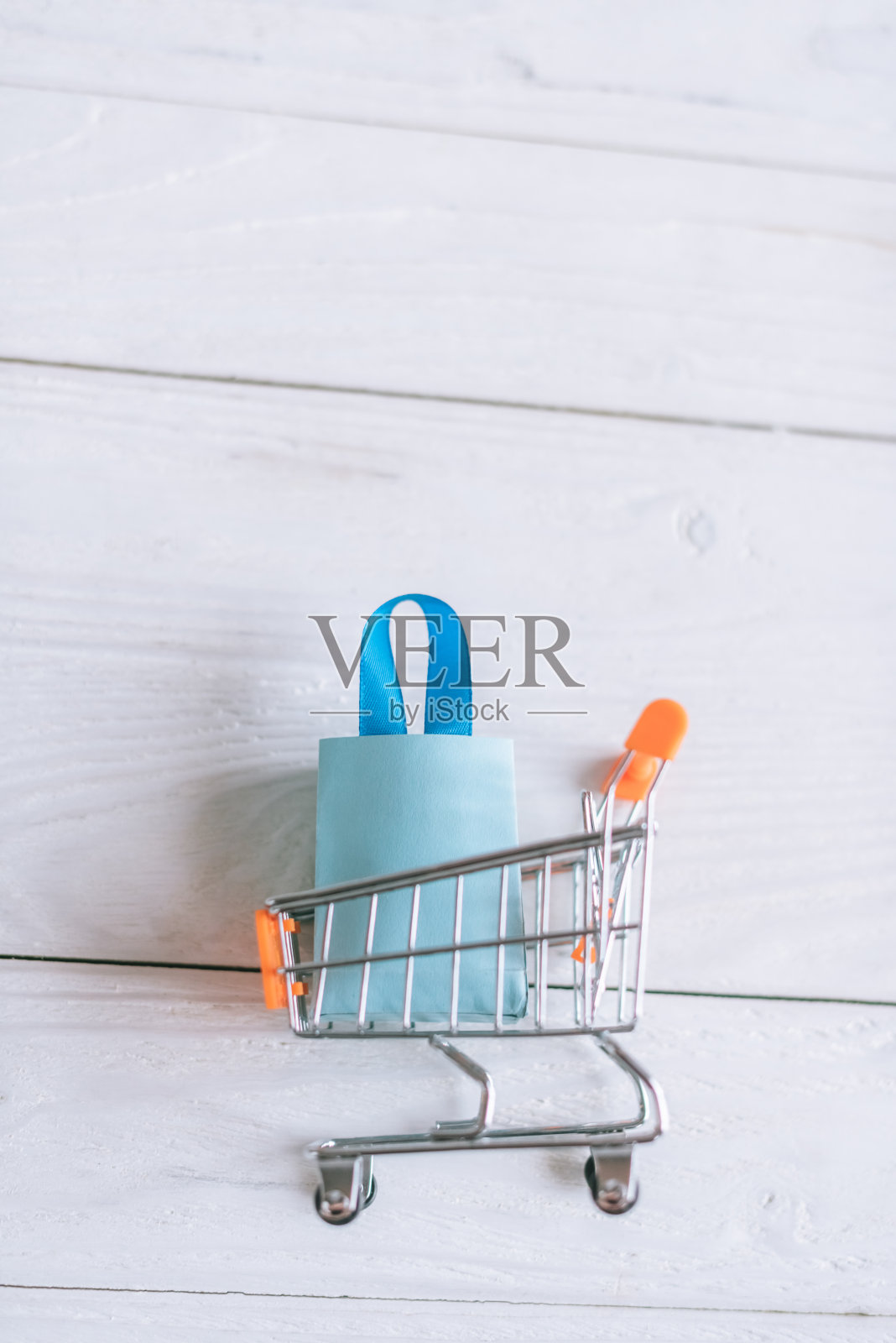 俯视图玩具包装和购物袋在推车上木制的桌子照片摄影图片