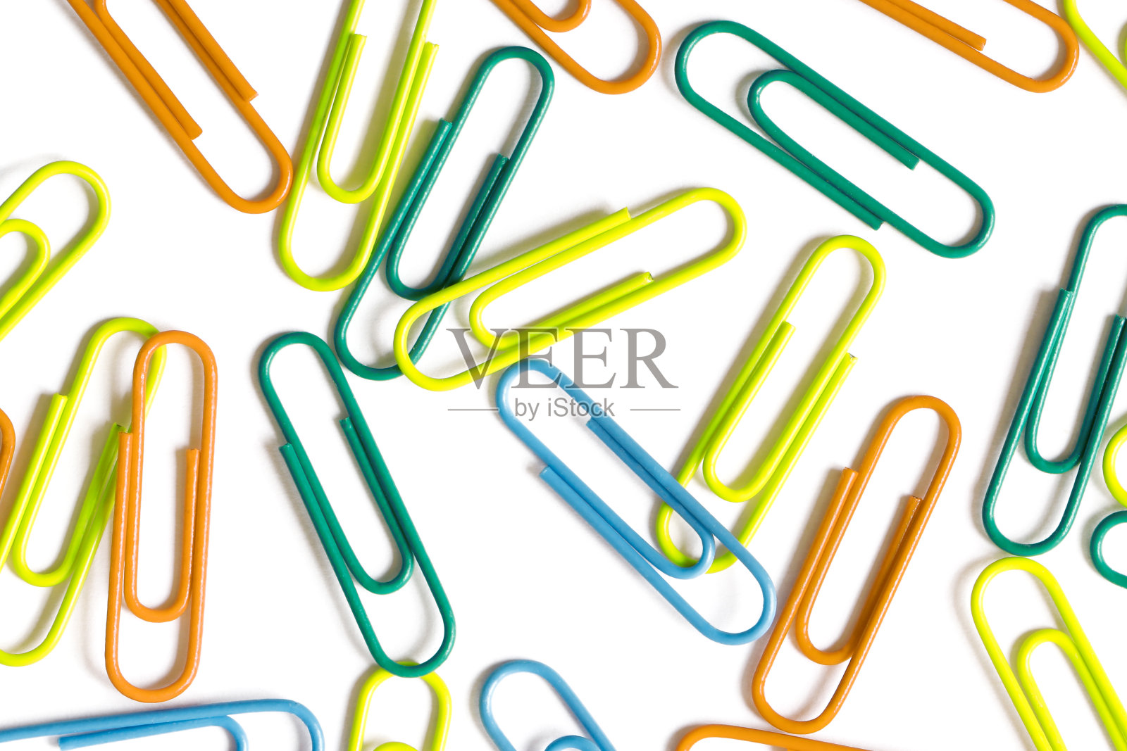 各种颜色的回形针在白色的背景照片摄影图片