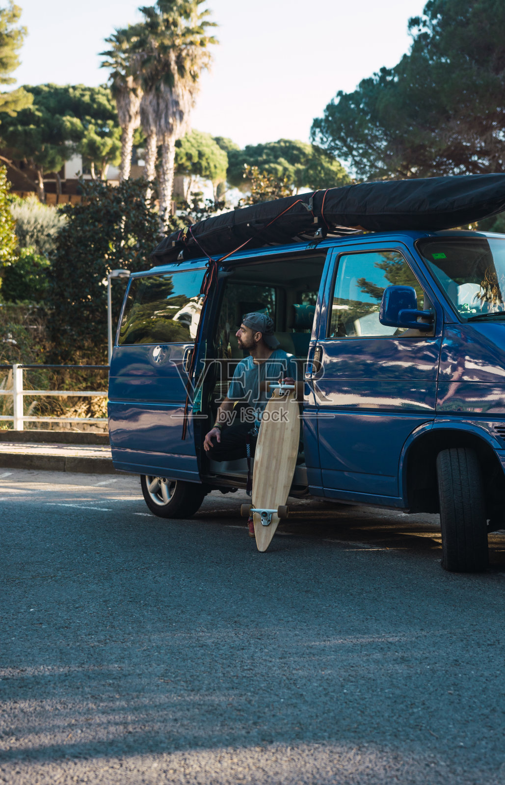 夕阳下,一个人在孤独的街道上练习他的长板照片摄影图片