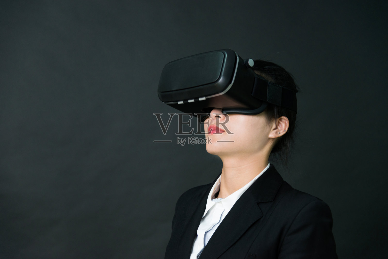 女商人在黑色背景上使用虚拟现实模拟器照片摄影图片