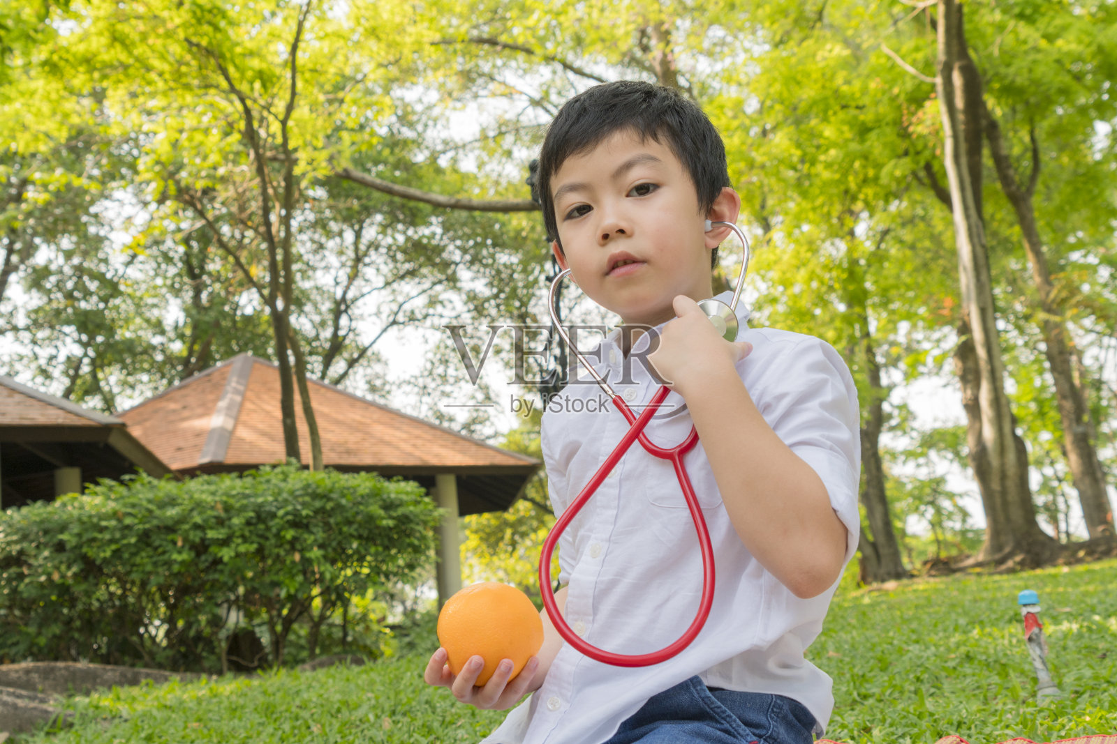 男孩使用听诊器和玩水果橙色符号照片摄影图片