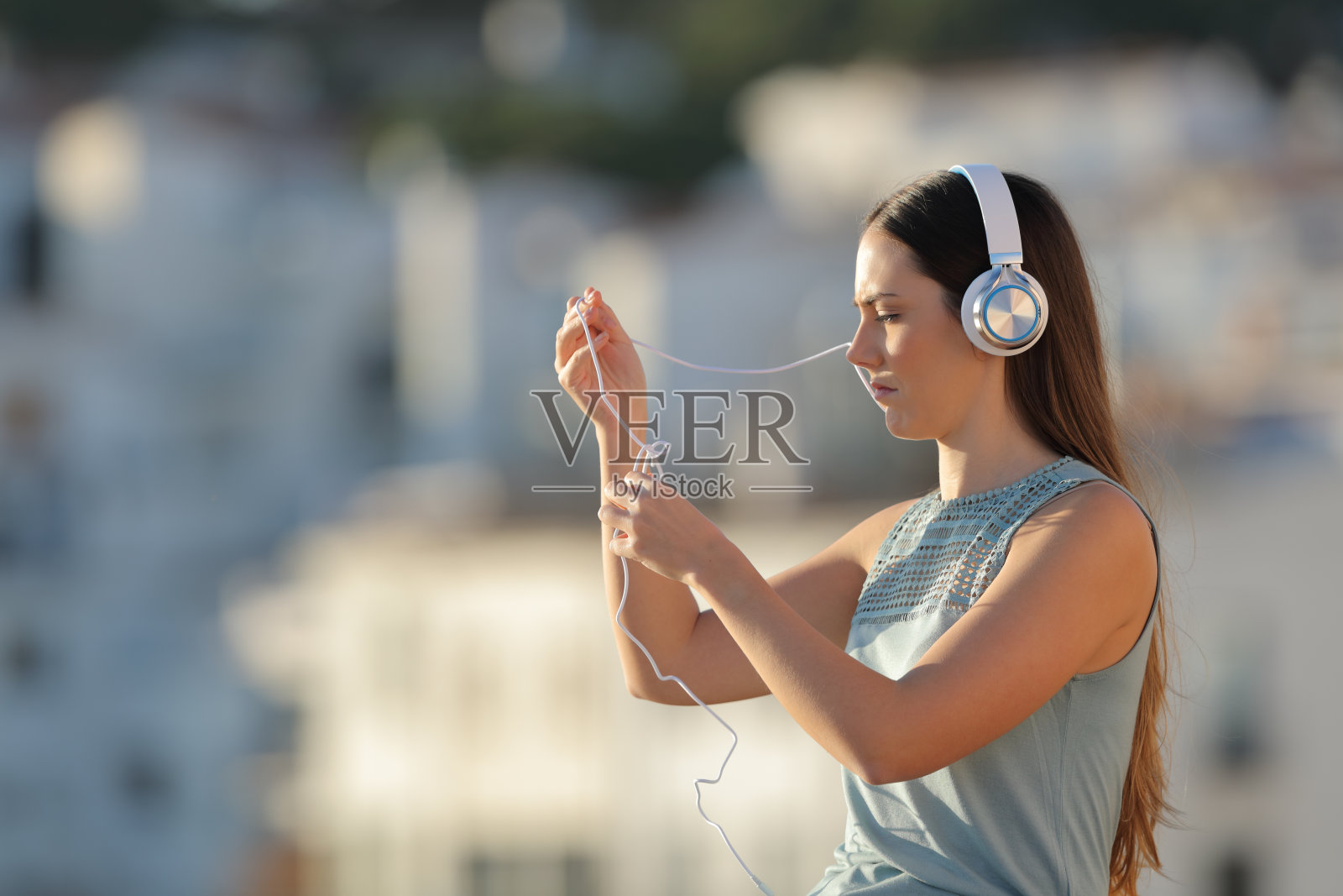 一个女人在和耳机线打架照片摄影图片