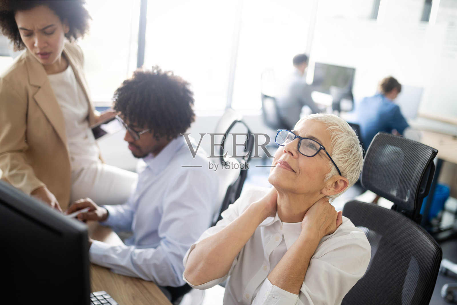 成熟的职场女性在办公室里有压力和头痛照片摄影图片