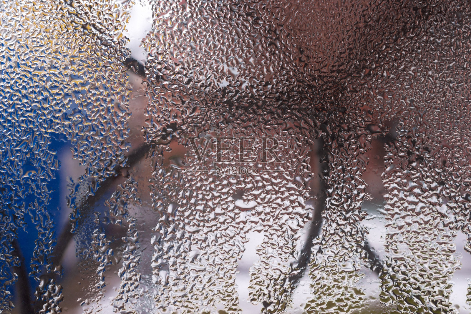 在模糊的背景下,玻璃窗户上的水滴靠近。滴在宏。窗口特写冷凝水。潮湿的空气。照片摄影图片