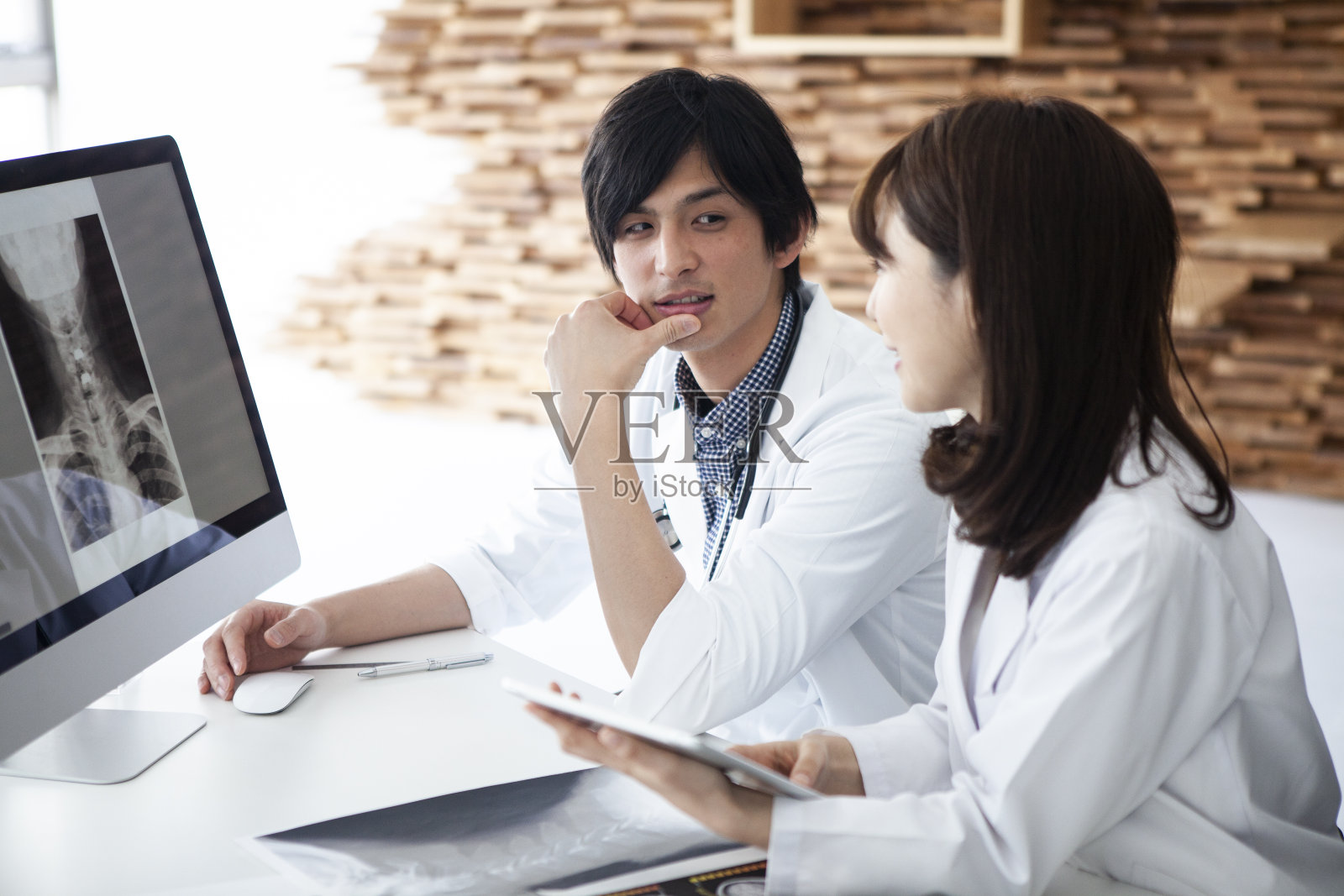 两个年轻的医生商量着。照片摄影图片