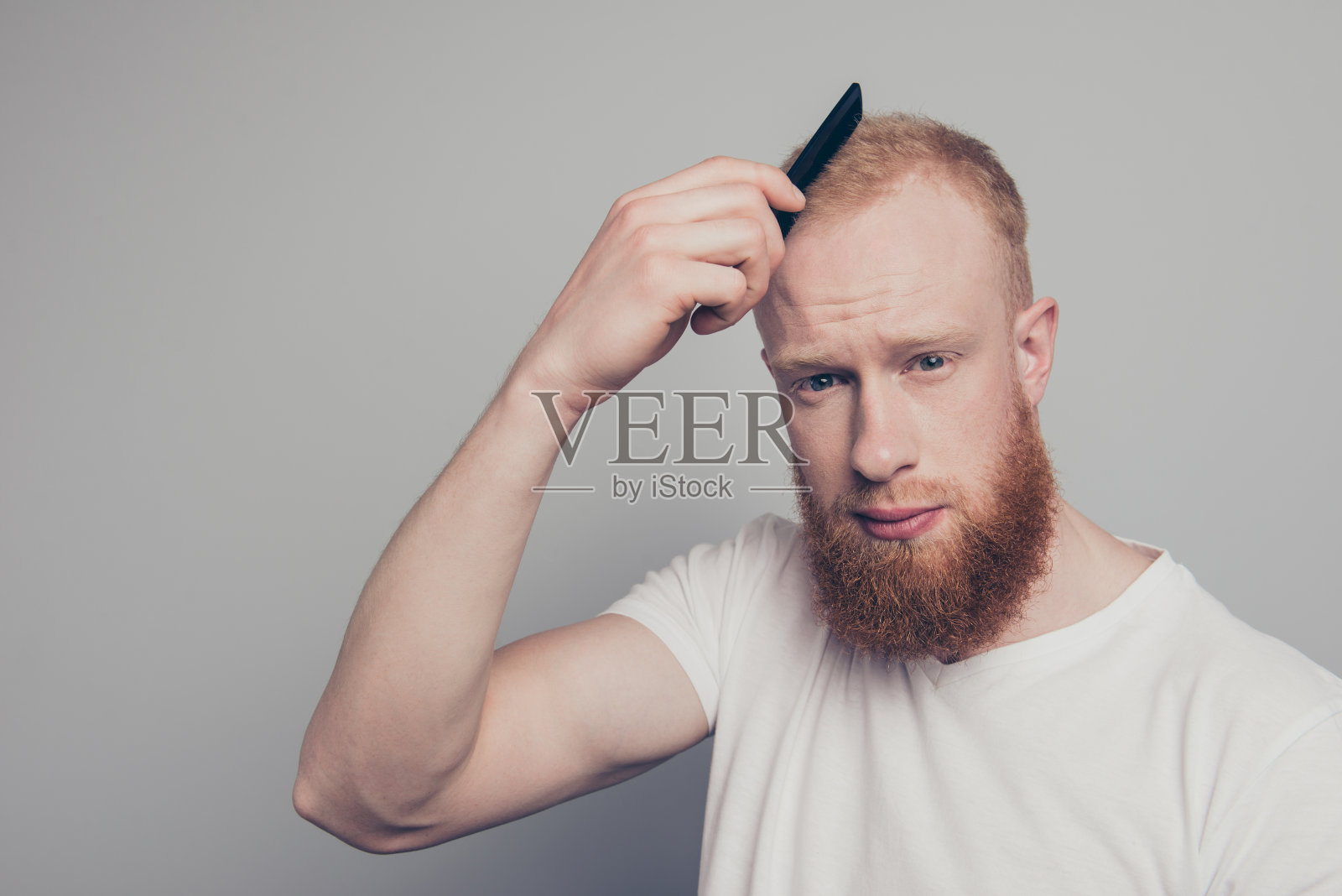 迷人帅气的绅士梳头发看相机斯坦照片摄影图片