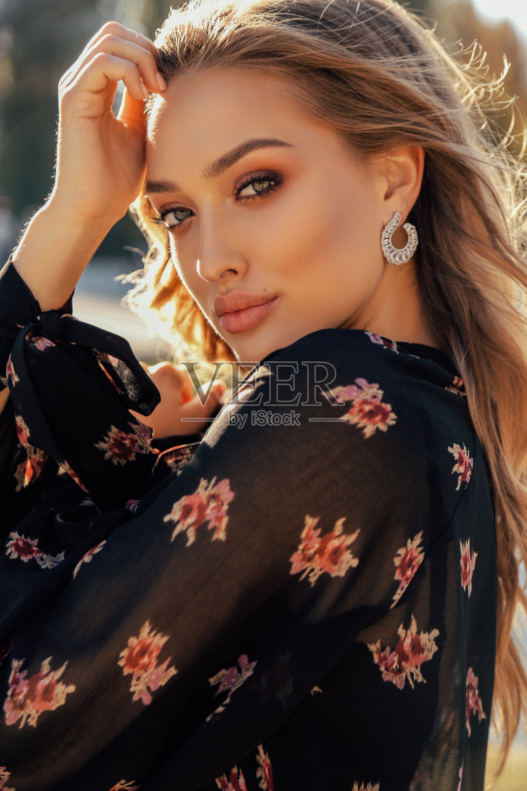 美丽的女人与金发在优雅的服装摆姿势在秋天公园照片摄影图片