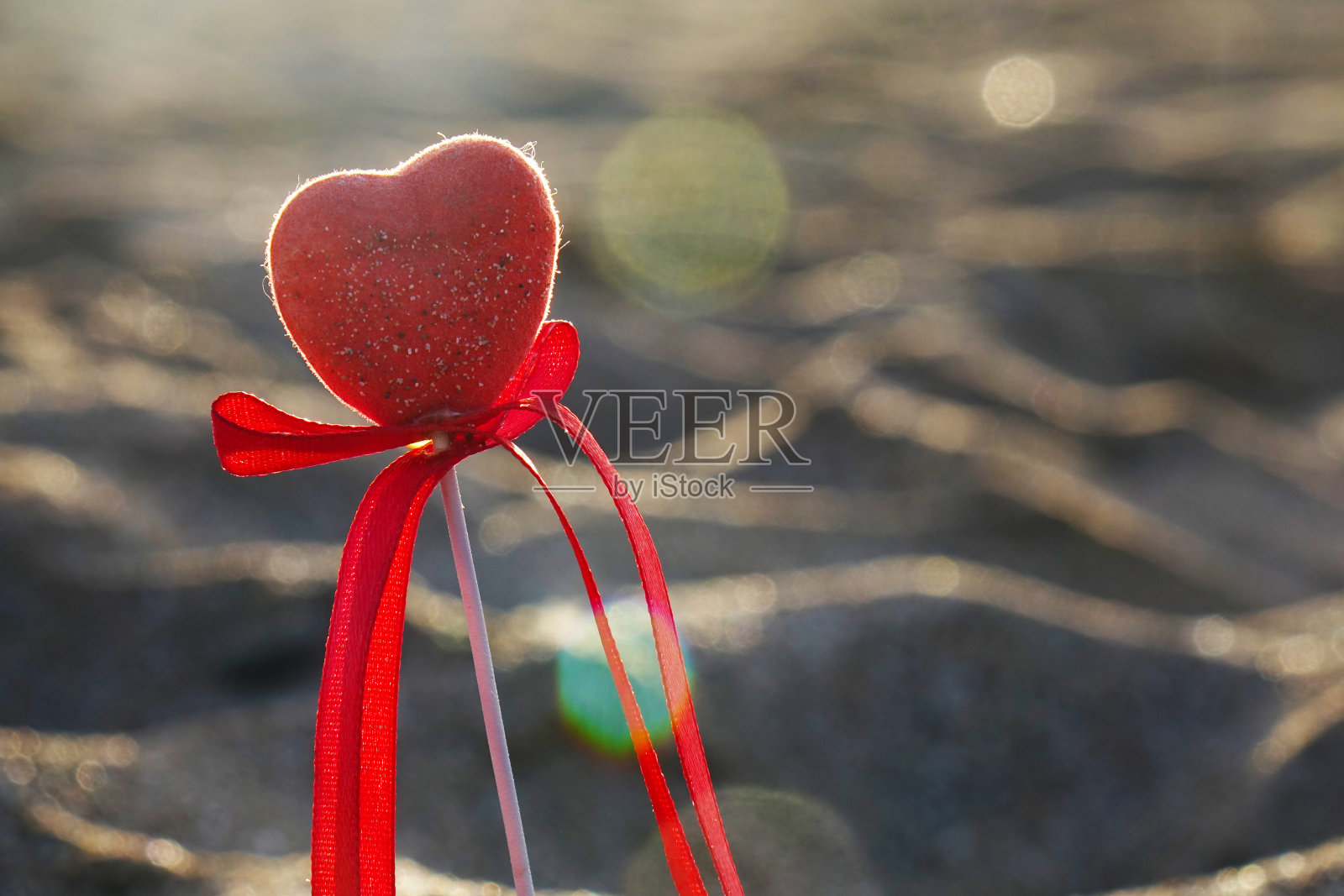 情人节贺卡的概念,红心在原始的沙滩,蜜月假期的背景。照片摄影图片