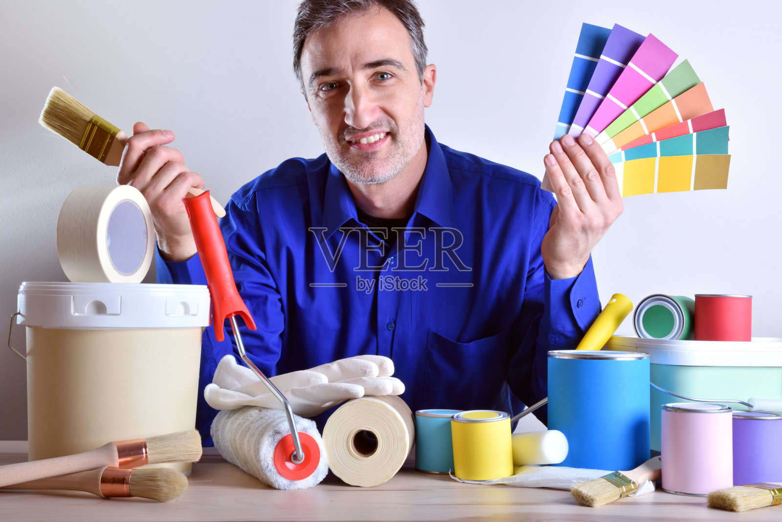 微笑的工人在桌子上展示绘画工具照片摄影图片