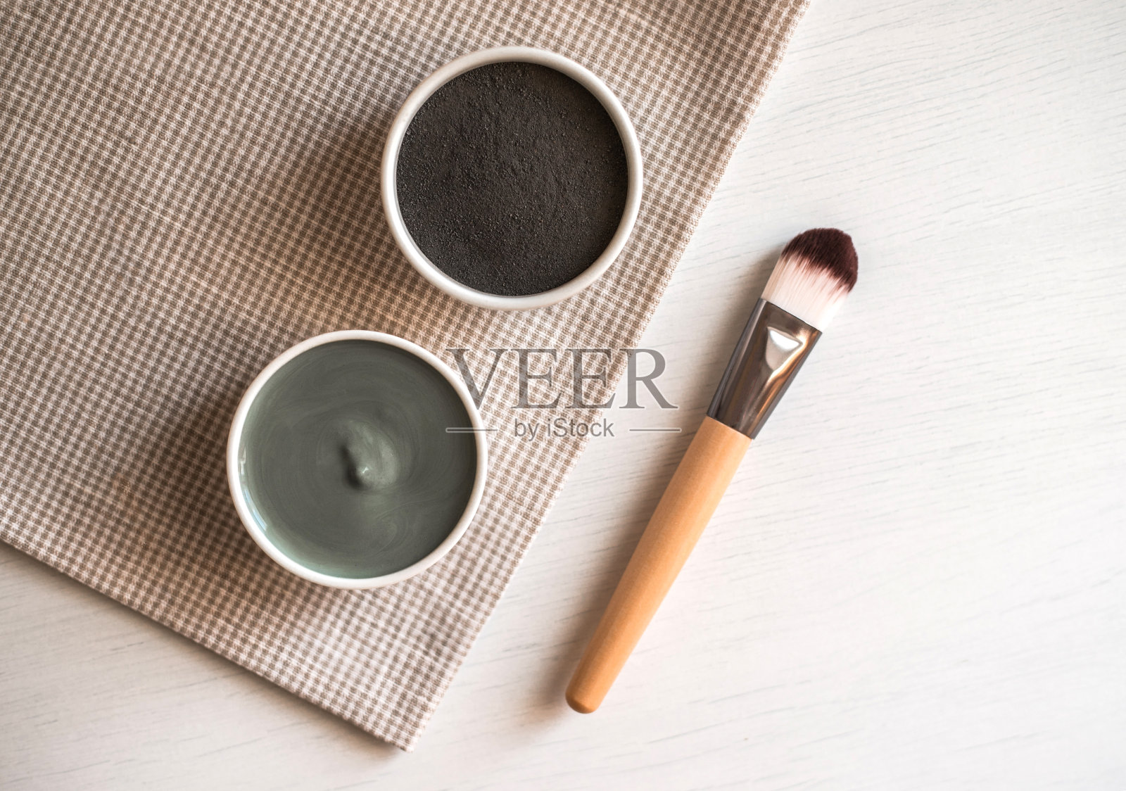 天然化妆面膜在陶瓷碗纺织背景。照片摄影图片