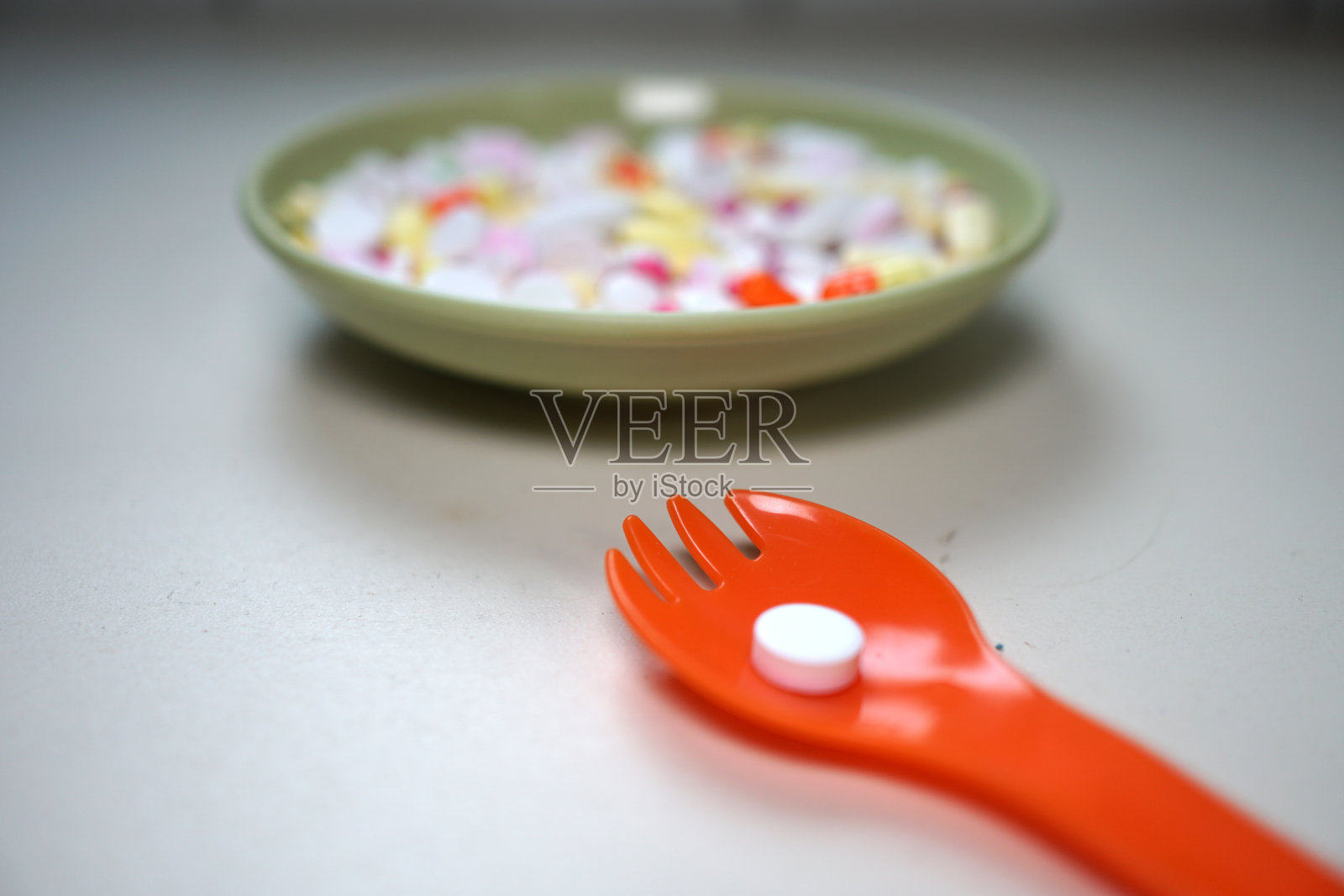 盘子里盛放的各种颜色药物和勺子照片摄影图片