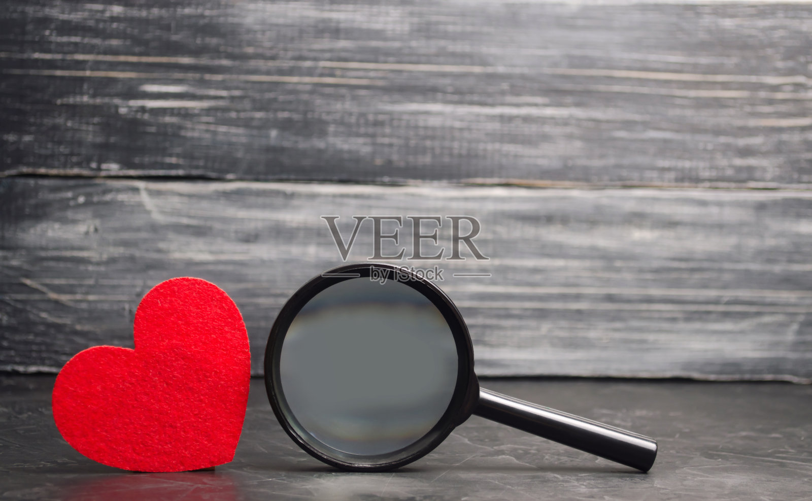 红心和放大镜。爱和关系的概念。寻找爱。情人节。孤独。找一个献血者输血。医学概念。慈善基金会。照片摄影图片