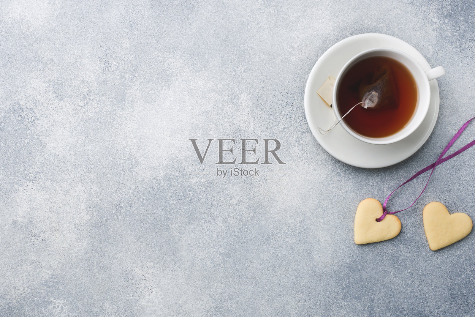 在灰色的背景上自制的心形饼干和一杯茶。副本的空间。情人节的概念照片摄影图片