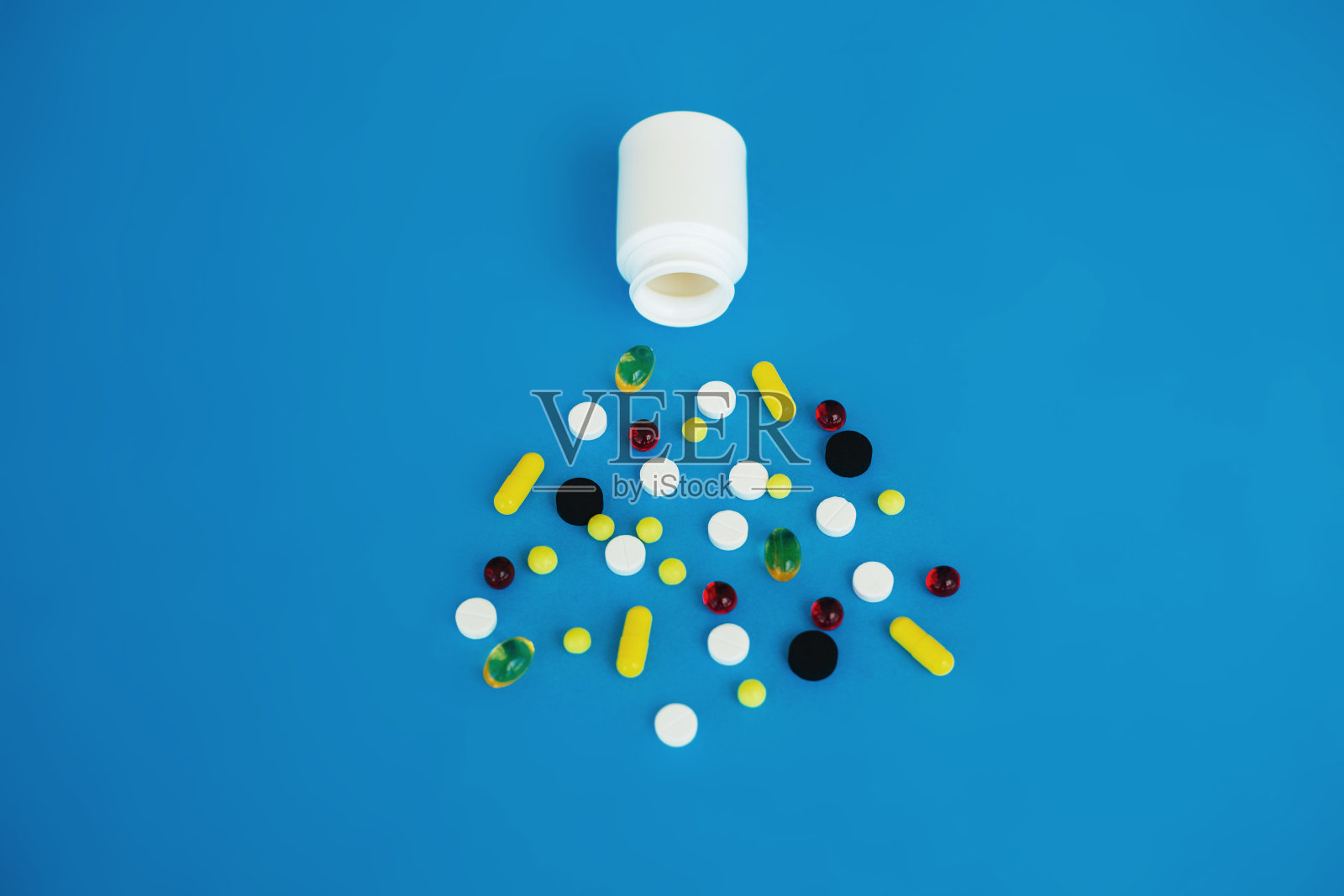 医学药。蓝色背景上的彩色药丸和胶囊。药房主题,胶囊药丸与药物抗生素包装照片摄影图片