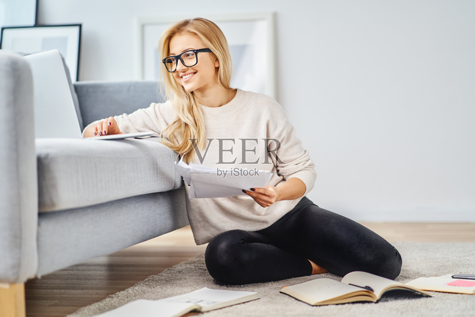 坐在家里用笔记本电脑和笔记复习准备上大学的快乐女人照片摄影图片