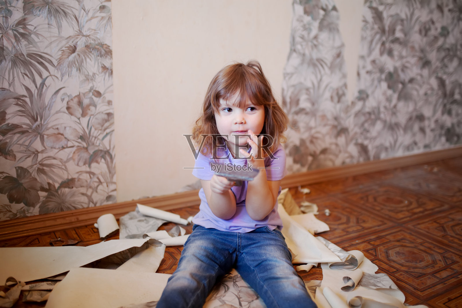可爱的小女孩拿着油灰刀修墙照片摄影图片