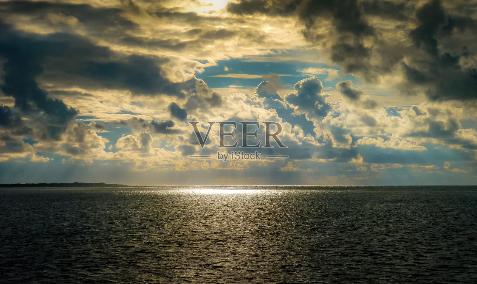 阳光亲吻着大海。光线照在水面上。照片摄影图片