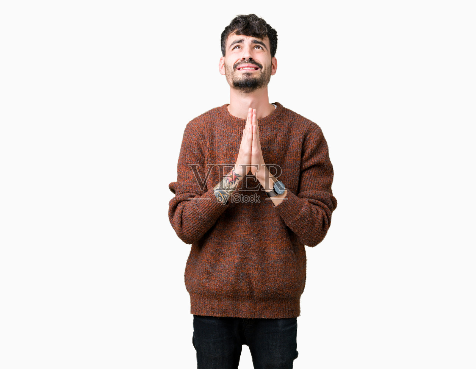 年轻英俊的男子穿着冬季毛衣越过孤立的背景,双手一起乞讨和祈祷,脸上充满希望的表情非常激动和担心。请求宽恕。宗教的概念。照片摄影图片