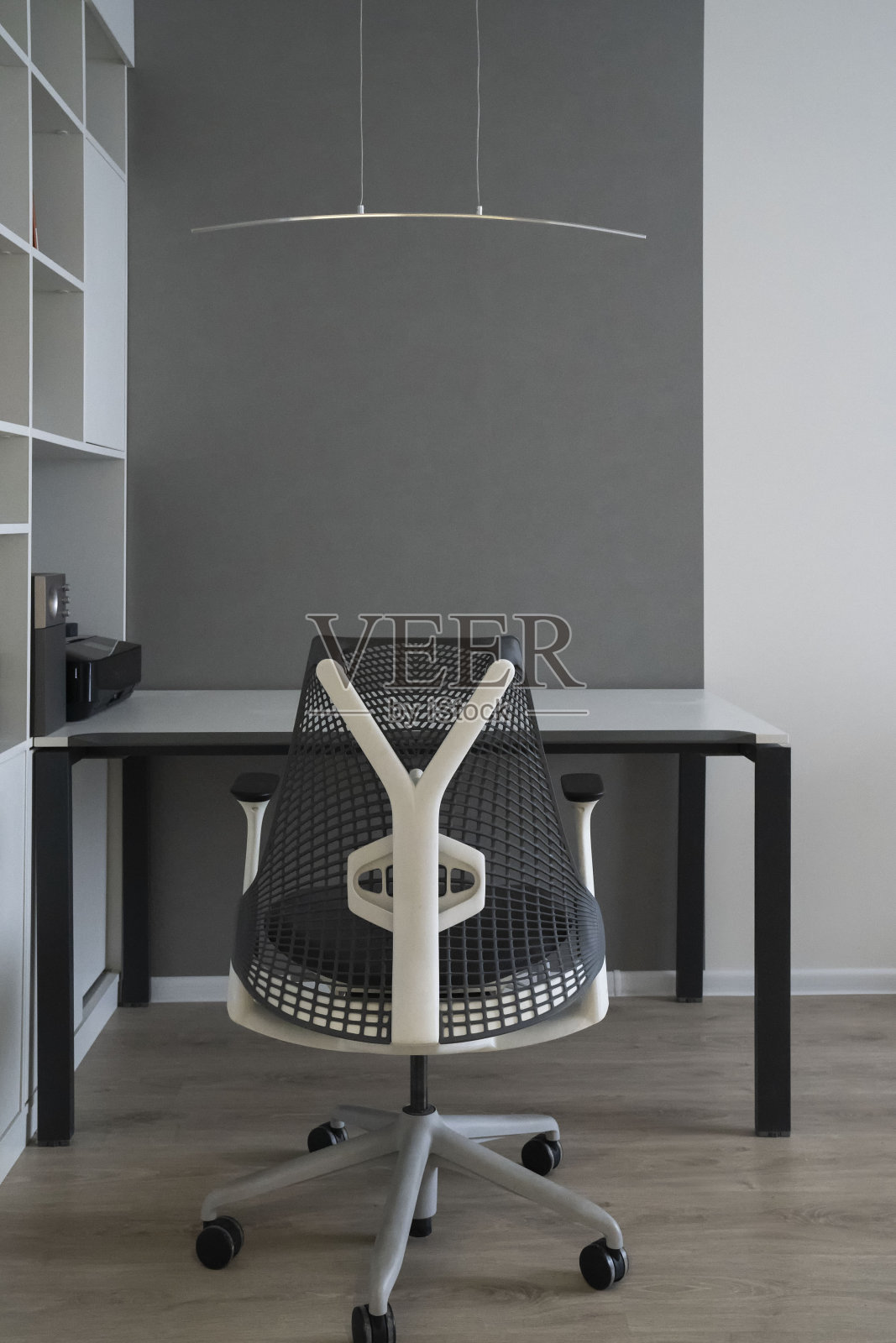 办公室内部配备现代舒适的工作空间-电脑桌,矫形椅和自然采光。照片摄影图片