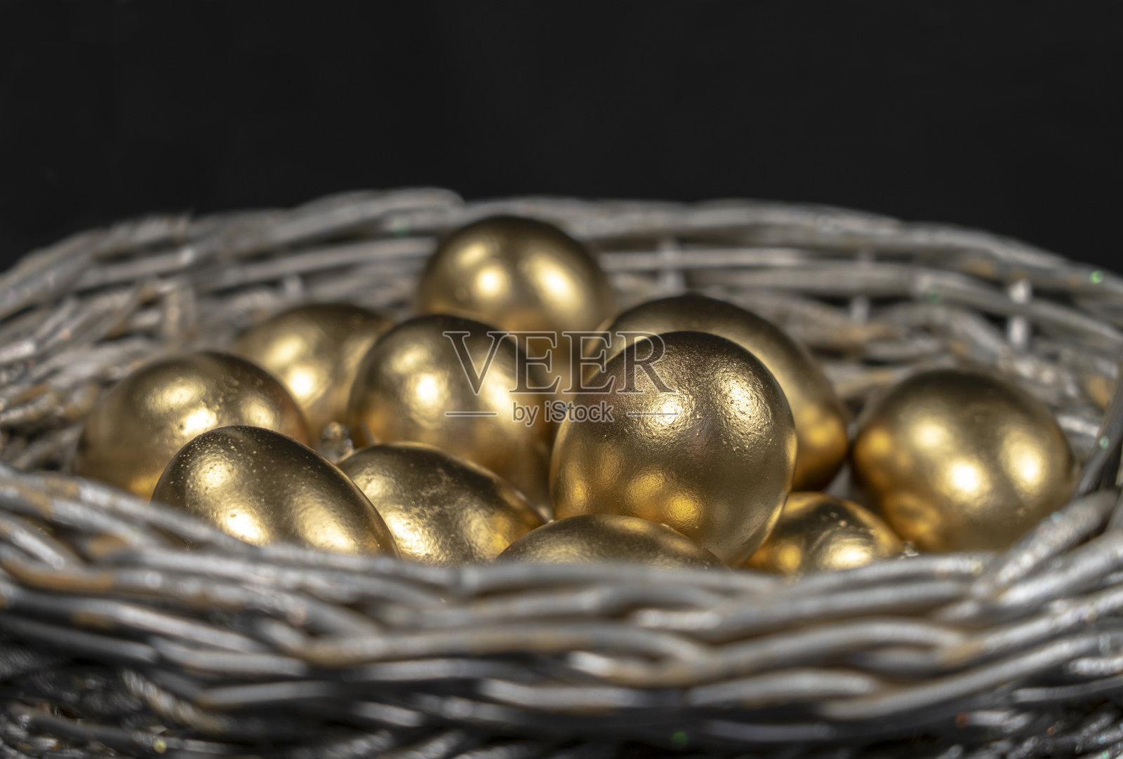 金蛋放在银篮子里,特写照片摄影图片