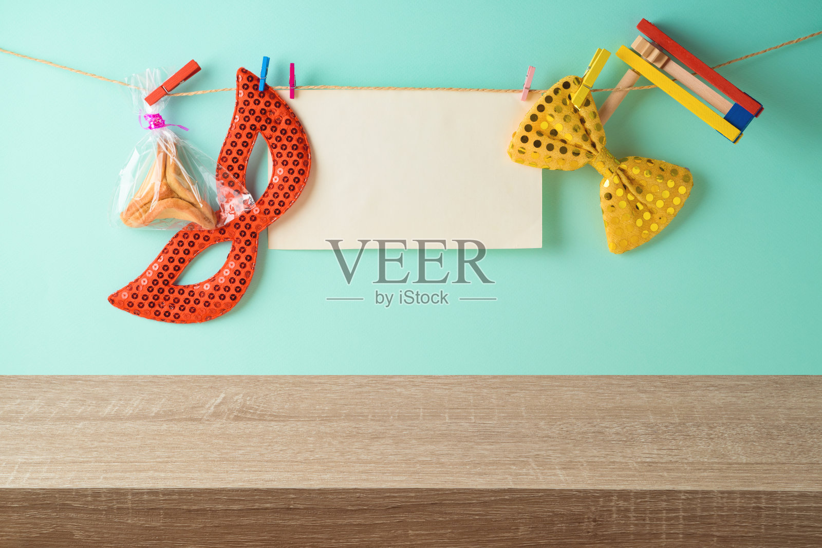 犹太节日普林节的节日背景有空木桌、纸纸条、狂欢节面具和哈曼塔什饼干。照片摄影图片