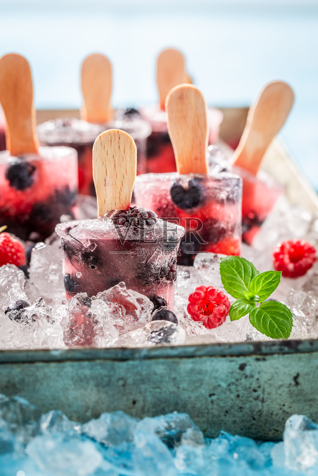 用小棍子夹着浆果的自制冰淇淋照片摄影图片