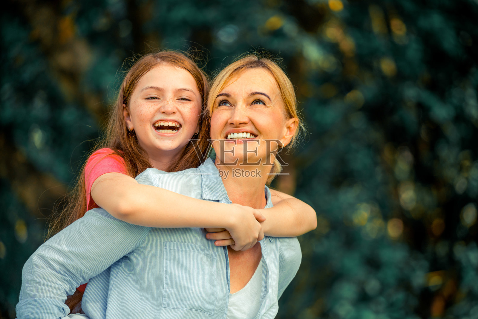 放松快乐的妈妈和小女儿在户外的公园里。父母和孩子的概念。照片摄影图片